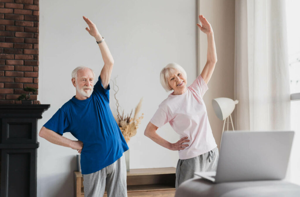 A senior man and a senior woman with white hair doing posture exercise while at home.